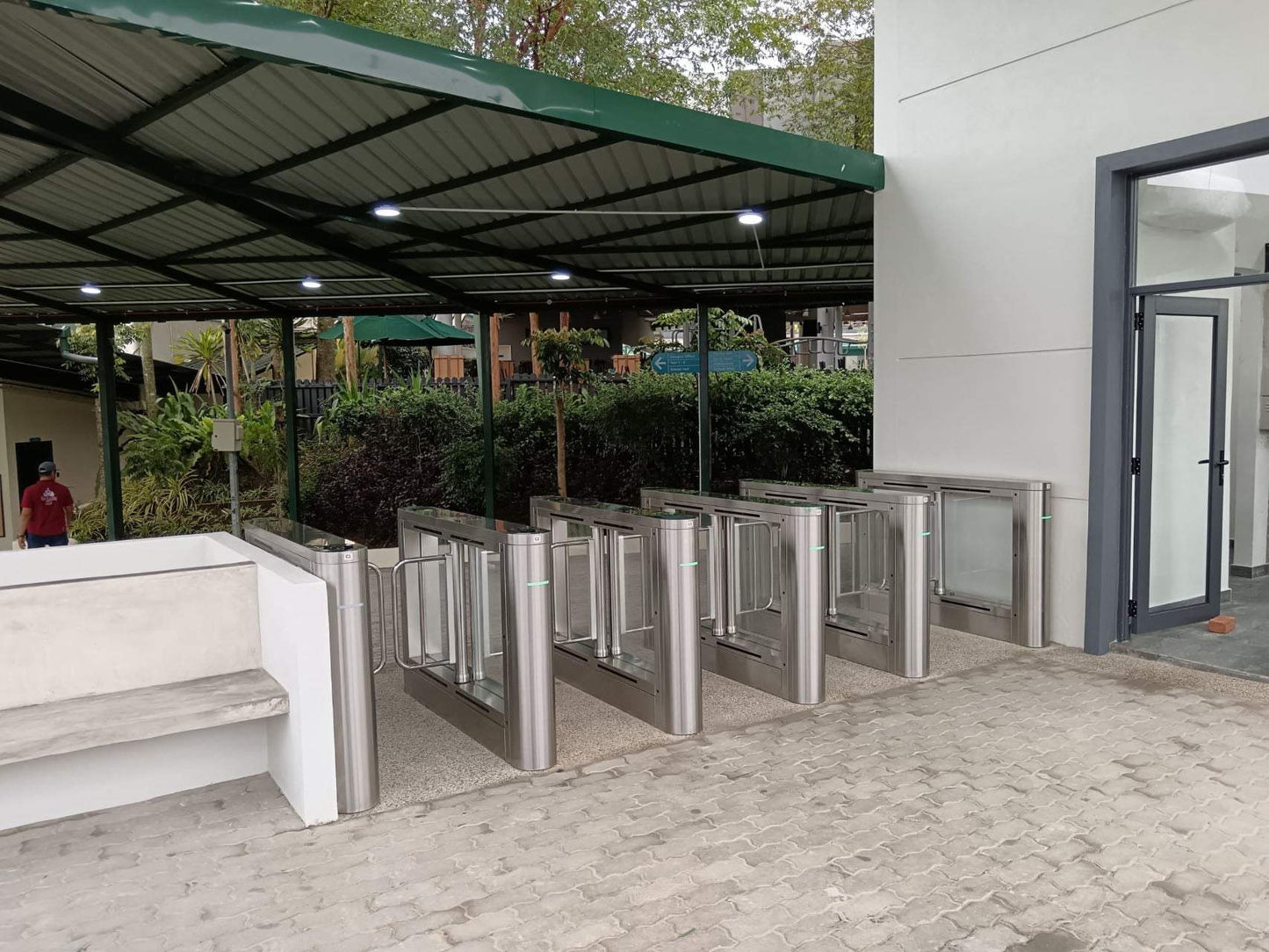 Evolve ES200 External Speed Lane Gate installed outdoors with shelter, featuring stainless steel and Plexiglas design.