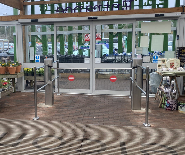 Retail Entrance Control Systems featuring swing gates at a store entrance.