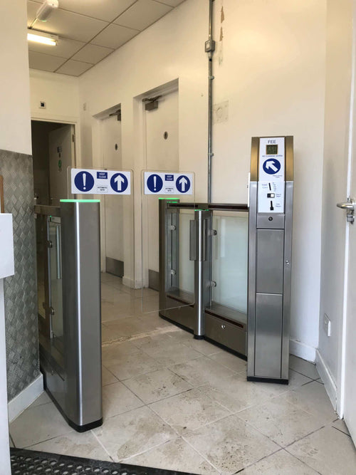 ES150 Coin Operated Speed Gate installation in public restroom with clear directional signs.